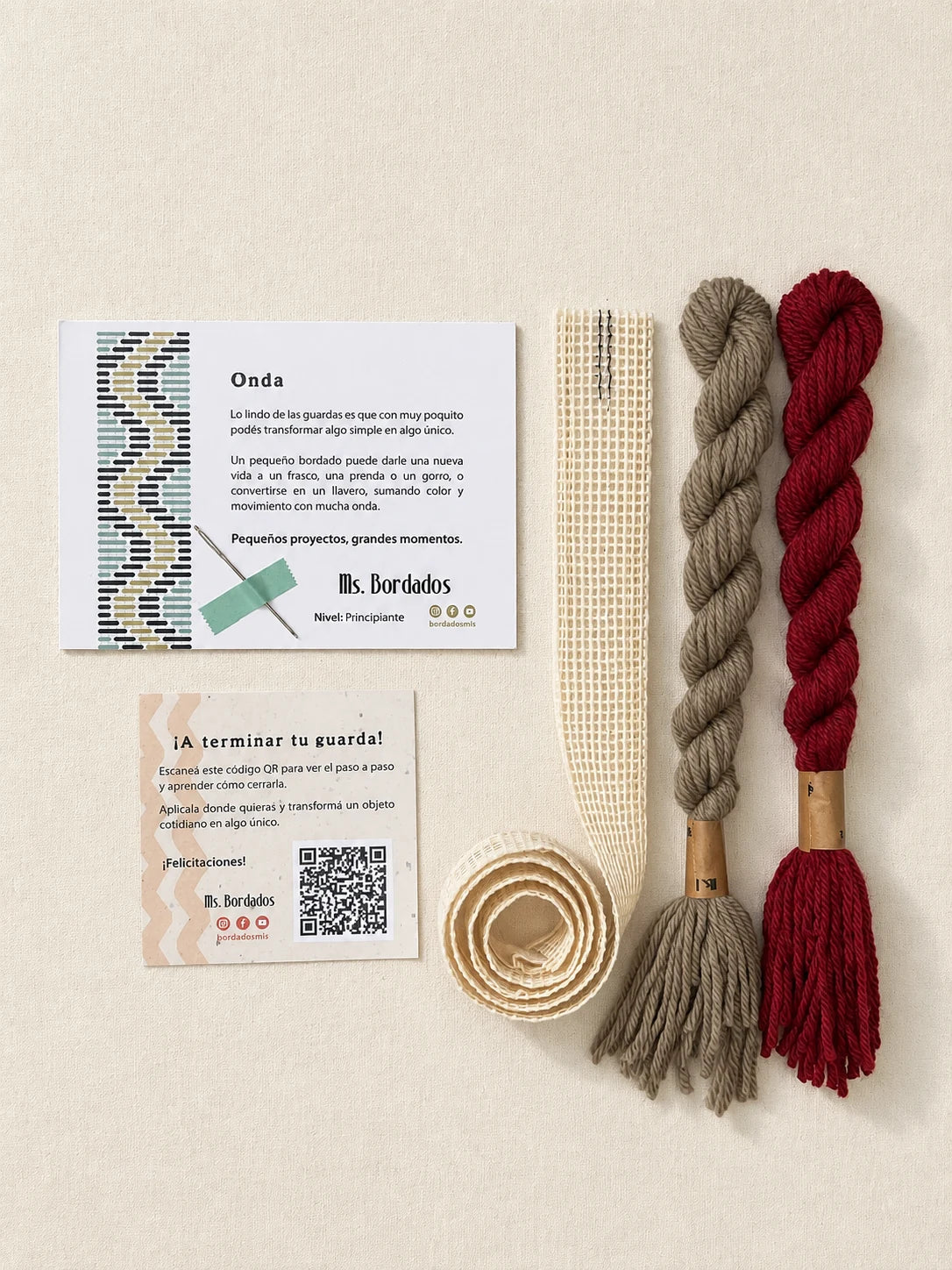 Componentes del Kit Franja Onda Amapola (formato Guarda larga): cañamazo de 75 × 5 cm, lanas 100% uruguayas en Verde eucaliptus y Rojo, aguja, manual impreso y tarjeta con el QR del video para terminar tu guarda — Ms. Bordados