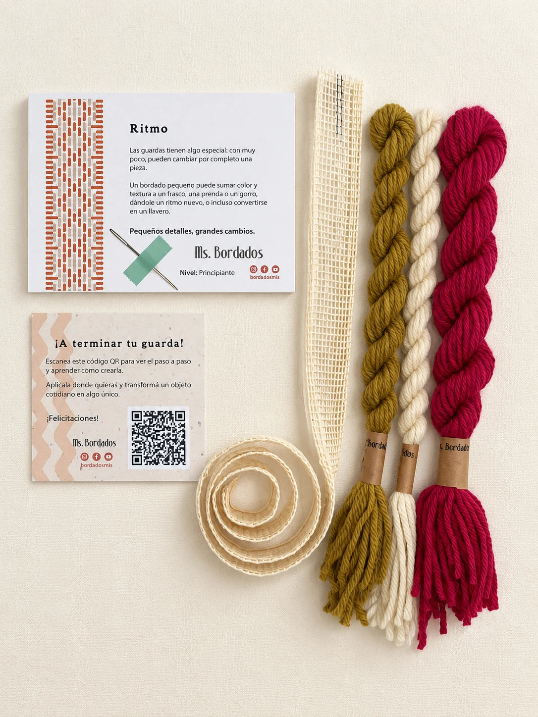 Componentes del Kit Franja Ritmo Vintage (formato Guarda larga): cañamazo de 75 × 5 cm, lanas 100% uruguayas en Magenta viejo, Oro viejo y Crudo, aguja, manual impreso y tarjeta con el QR del video para terminar tu guarda — Ms. Bordados