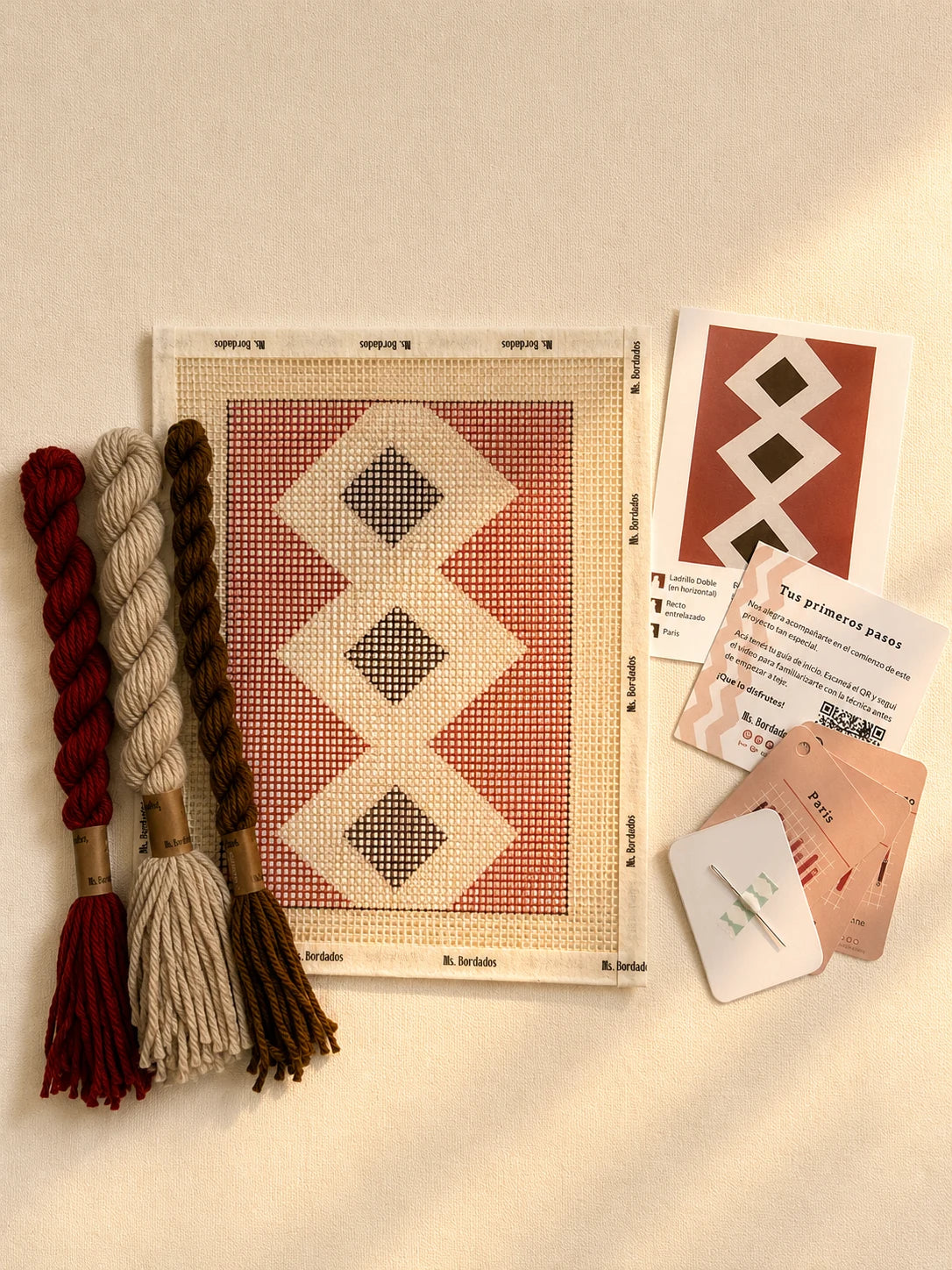 Componentes del Kit Cuadrito Senda: cañamazo con el diseño, lanas, aguja y tarjetas de puntadas — Ms. Bordados