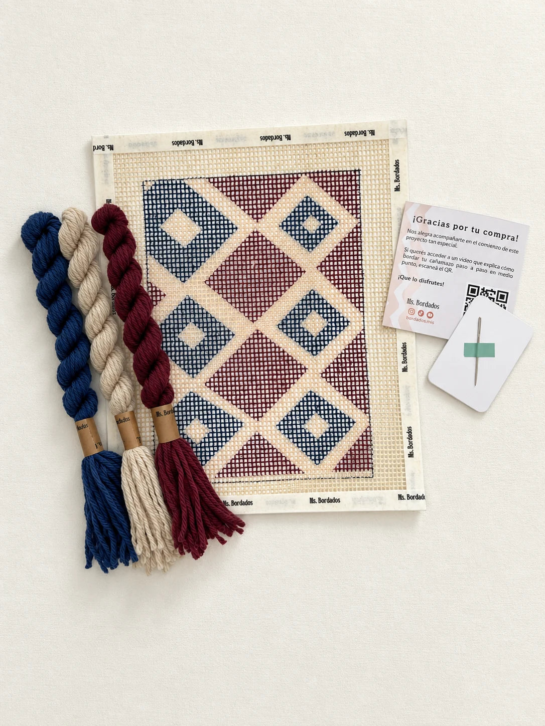 Componentes del Kit Cuadrito Vitral: cañamazo con el diseño, lanas en azul, bordó y beige, y aguja — Ms. Bordados