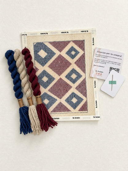 Componentes del Kit Cuadrito Vitral: cañamazo con el diseño, lanas en azul, bordó y beige, y aguja — Ms. Bordados