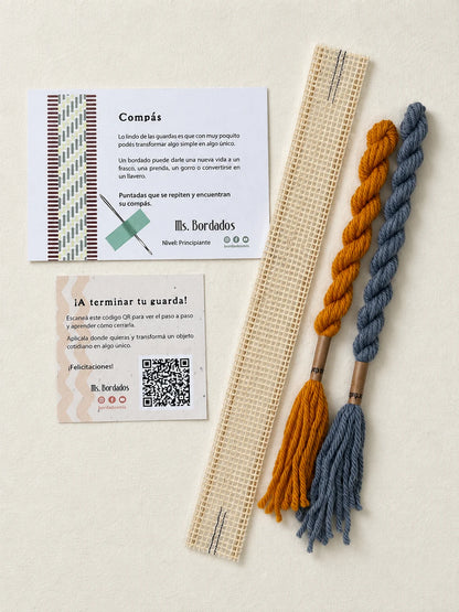 Componentes del Kit Franja Compás Provenza (formato Guarda corta): cañamazo de 30 × 5 cm, lanas 100% uruguayas en Celeste y Amarillo, aguja, manual impreso y tarjeta con el QR del video para terminar tu guarda — Ms. Bordados