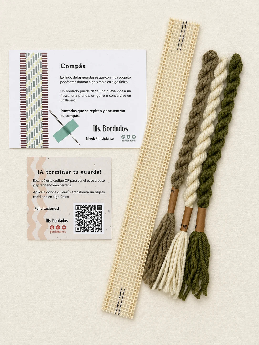 Componentes del Kit Franja Compás Salvia (formato Guarda corta): cañamazo de 30 × 5 cm, lanas 100% uruguayas en Crudo, Verde seco y Taupe, aguja, manual impreso y tarjeta con el QR del video para terminar tu guarda — Ms. Bordados