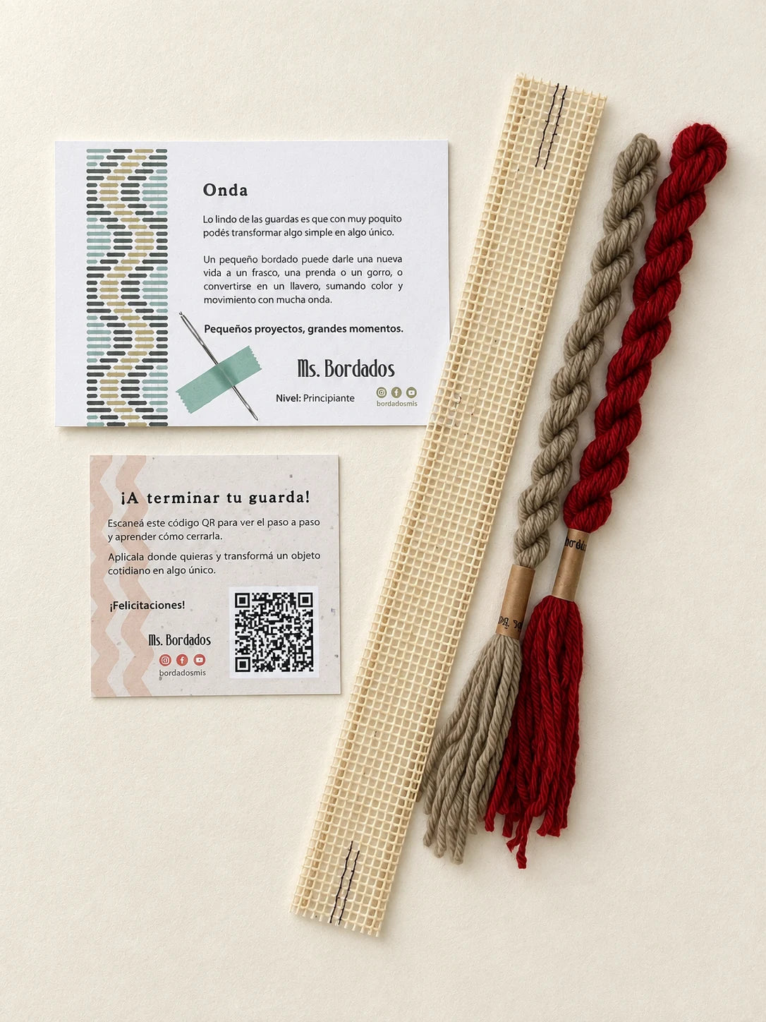 Componentes del Kit Franja Onda Amapola (formato Guarda corta): cañamazo de 30 × 5 cm, lanas 100% uruguayas en Verde eucaliptus y Rojo, aguja, manual impreso y tarjeta con el QR del video para terminar tu guarda — Ms. Bordados