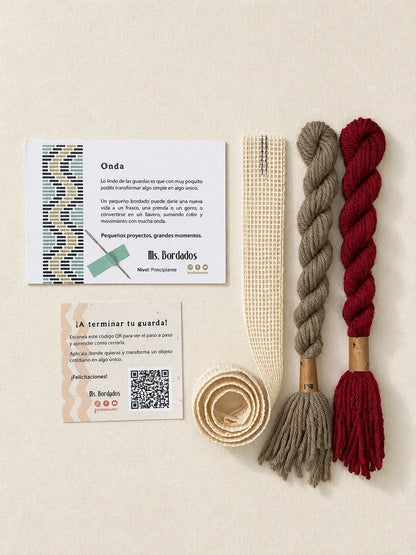 Componentes del Kit Franja Onda Amapola (formato Guarda larga): cañamazo de 75 × 5 cm, lanas 100% uruguayas en Verde eucaliptus y Rojo, aguja, manual impreso y tarjeta con el QR del video para terminar tu guarda — Ms. Bordados