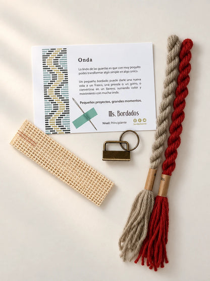 Componentes del Kit Franja Onda Amapola (formato Llavero): cañamazo, lanas 100% uruguayas en Verde eucaliptus y Rojo, aguja, manual impreso y herraje del llavero — Ms. Bordados