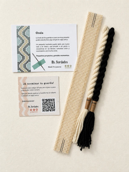 Componentes del Kit Franja Onda Cebra (formato Guarda corta): cañamazo de 30 × 5 cm, lanas 100% uruguayas en Negro y Crudo, aguja, manual impreso y tarjeta con el QR del video para terminar tu guarda — Ms. Bordados
