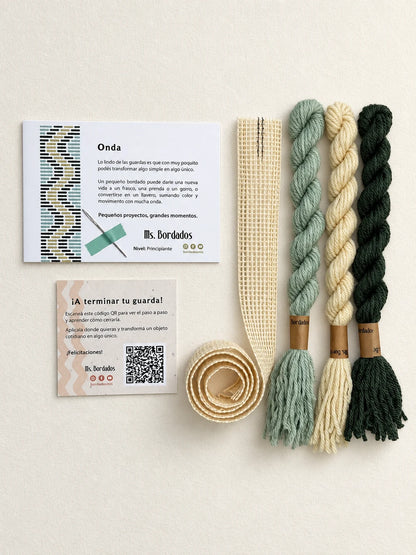 Componentes del Kit Franja Onda Pradera (formato Guarda larga): cañamazo de 75 × 5 cm, lanas 100% uruguayas en Amarillo, Verde y Verde agua, aguja, manual impreso y tarjeta con el QR del video para terminar tu guarda — Ms. Bordados