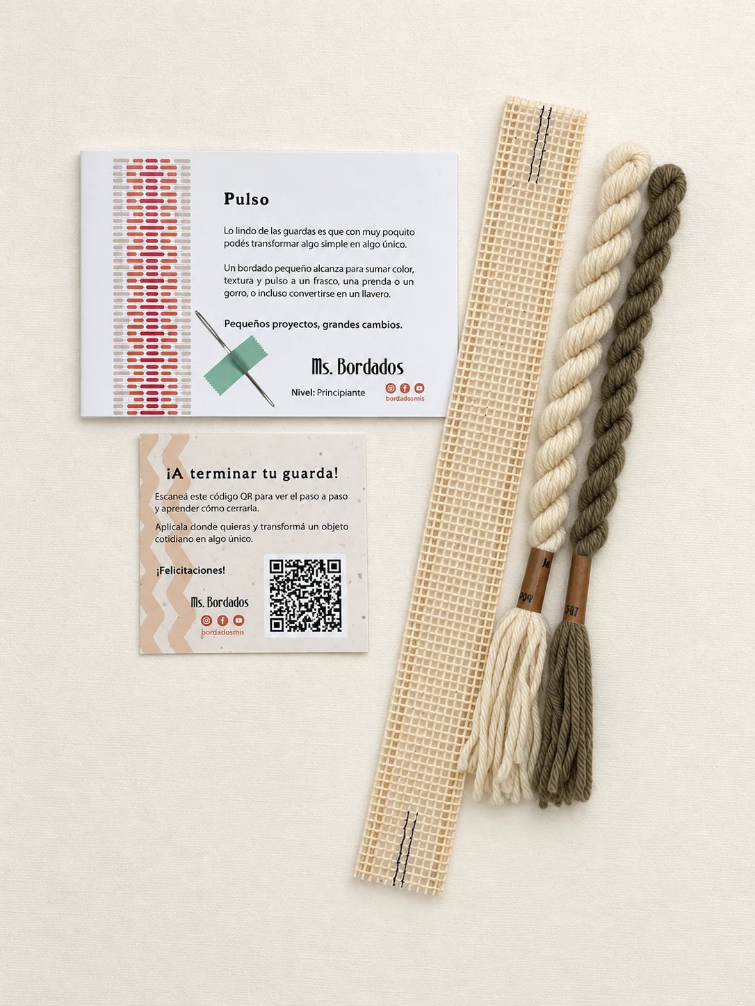 Componentes del Kit Franja Pulso Lino (formato Guarda corta): cañamazo de 30 × 5 cm, lanas 100% uruguayas en Crudo y Topo, aguja, manual impreso y tarjeta con el QR del video para terminar tu guarda — Ms. Bordados