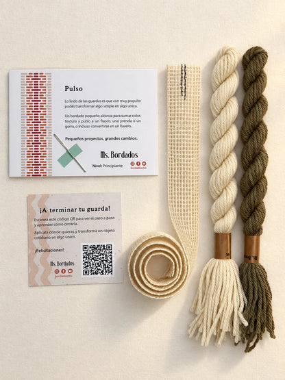 Componentes del Kit Franja Pulso Lino (formato Guarda larga): cañamazo de 75 × 5 cm, lanas 100% uruguayas en Crudo y Topo, aguja, manual impreso y tarjeta con el QR del video para terminar tu guarda — Ms. Bordados