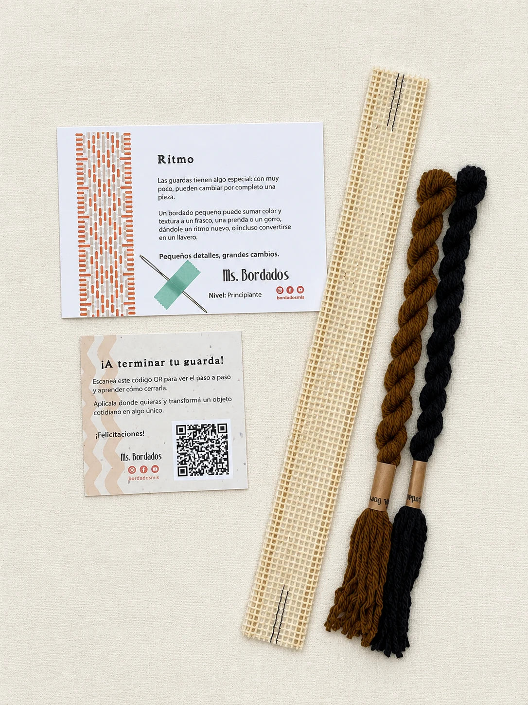 Componentes del Kit Franja Ritmo Café (formato Guarda corta): cañamazo de 30 × 5 cm, lanas 100% uruguayas en Tostado y Negro, aguja, manual impreso y tarjeta con el QR del video para terminar tu guarda — Ms. Bordados