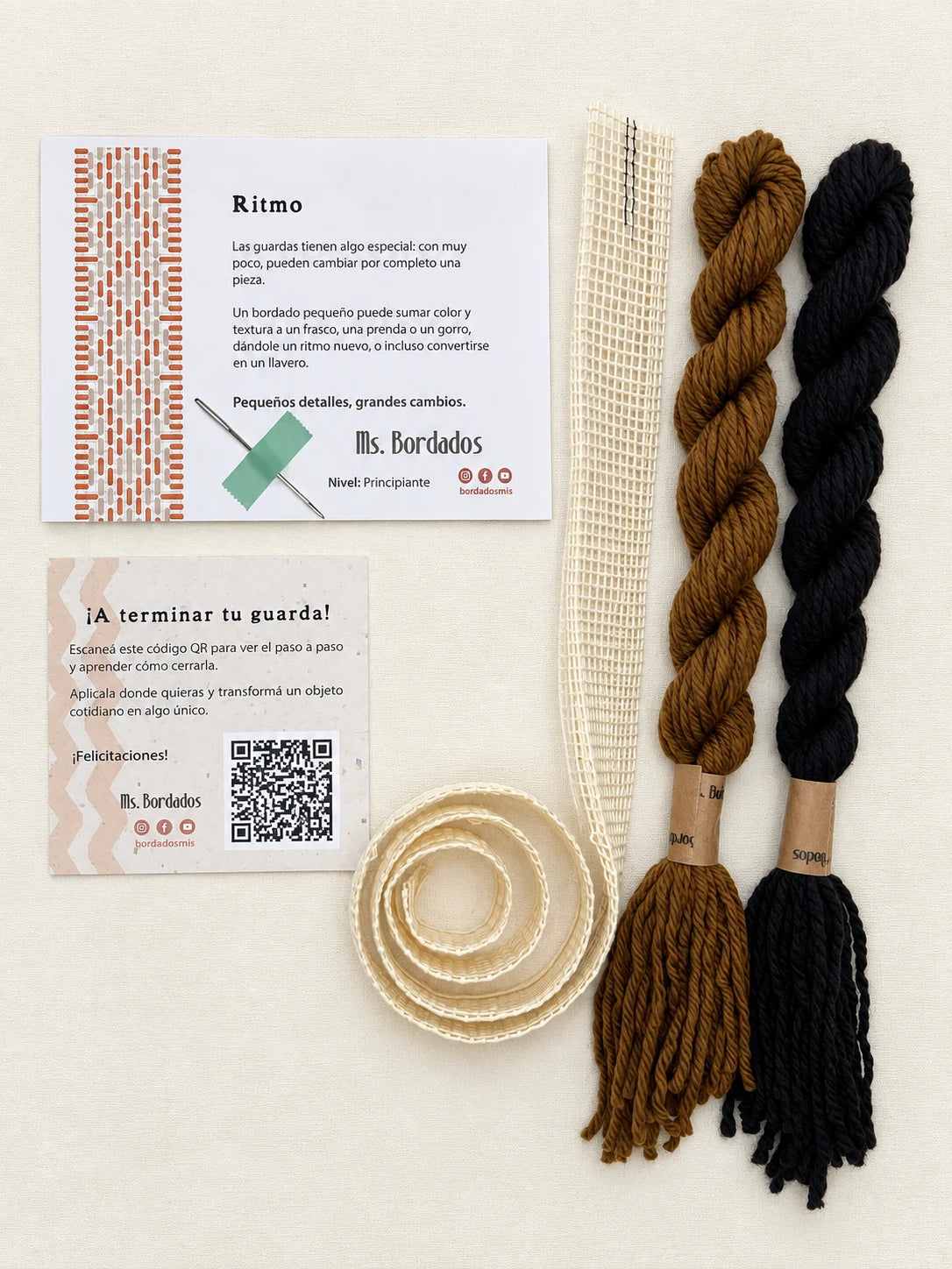 Componentes del Kit Franja Ritmo Café (formato Guarda larga): cañamazo de 75 × 5 cm, lanas 100% uruguayas en Tostado y Negro, aguja, manual impreso y tarjeta con el QR del video para terminar tu guarda — Ms. Bordados