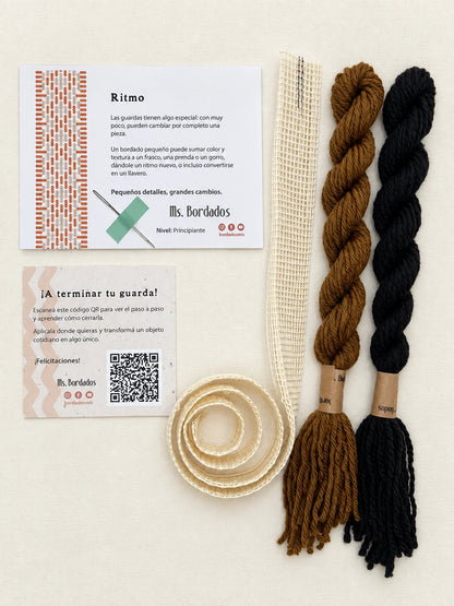 Componentes del Kit Franja Ritmo Café (formato Guarda larga): cañamazo de 75 × 5 cm, lanas 100% uruguayas en Tostado y Negro, aguja, manual impreso y tarjeta con el QR del video para terminar tu guarda — Ms. Bordados