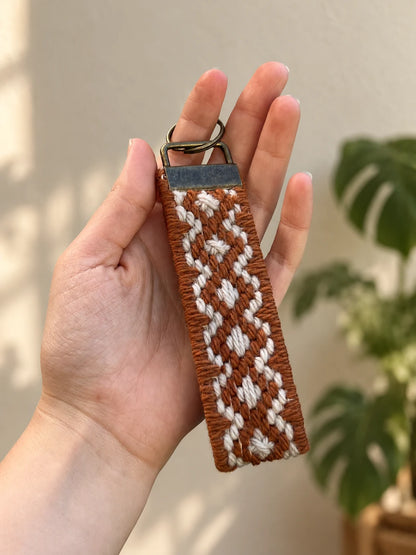 Llavero Franja Ritmo Cobre bordado sobre cañamazo, en Beige y Cobre, en la mano — Ms. Bordados