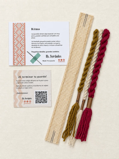 Componentes del Kit Franja Ritmo Vintage (formato Guarda corta): cañamazo de 30 × 5 cm, lanas 100% uruguayas en Magenta viejo, Oro viejo y Crudo, aguja, manual impreso y tarjeta con el QR del video para terminar tu guarda — Ms. Bordados