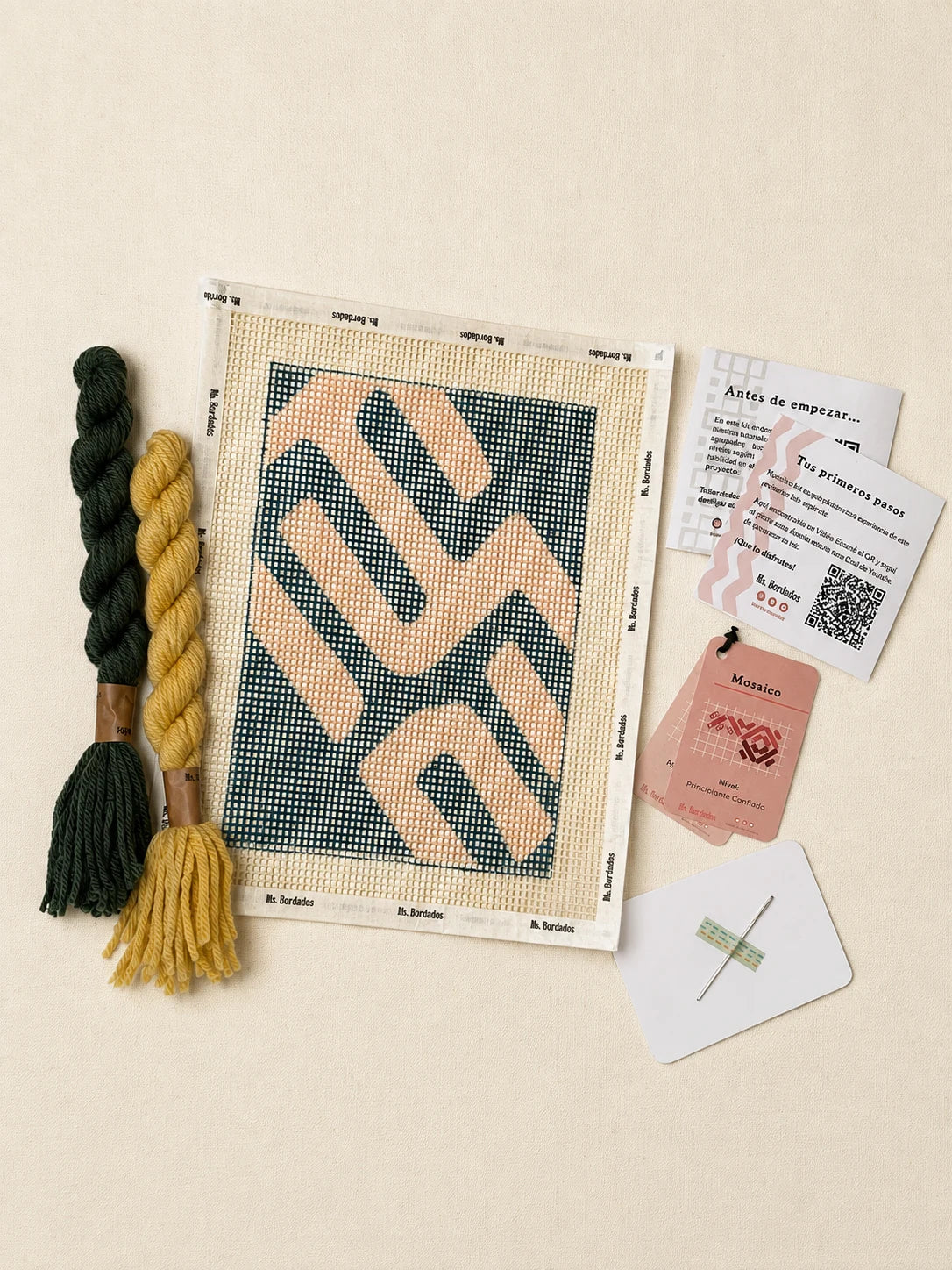 Componentes del Kit Cuadrito Kuba Tribal: cañamazo con el diseño, lanas verde esmeralda y amarillo pálido, aguja y tarjetas de puntadas — Ms. Bordados